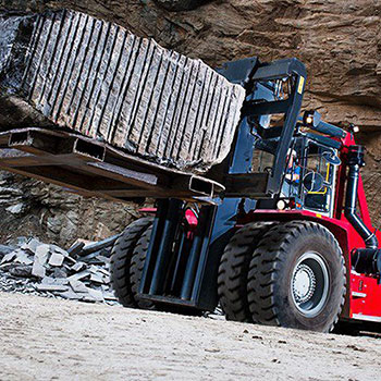 Picture showing a Kalmar Heavy Truck lifting a heavy load.